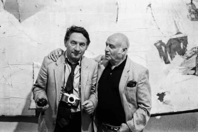 Mario Dondero – Mimmo Rotella (1918-2006) Il fotografo con Rotella davanti ad una sua opera Milano, 1990